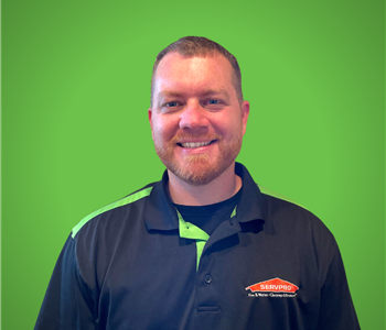 Male SERVPRO Employee smiling in front of a green background.