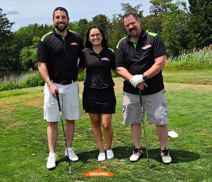 Female and Male Servpro Staff Golfing