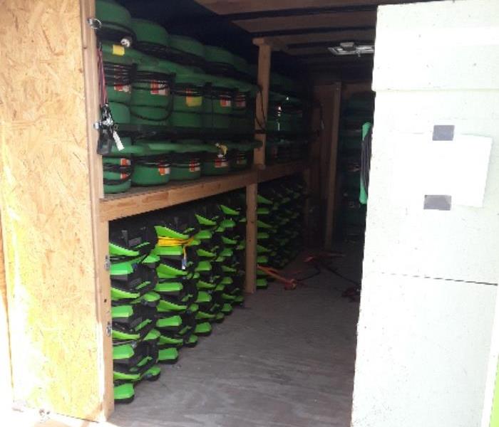 A SERVPRO trailer filled with green air movers.